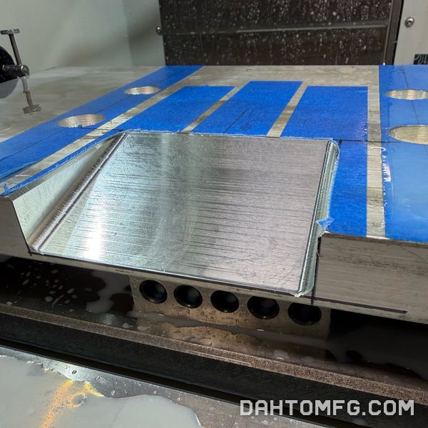 Close view of an angled face milled into an aluminum plate on a fixture