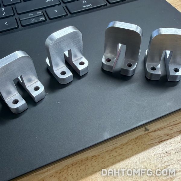 Four machined aluminum brackets