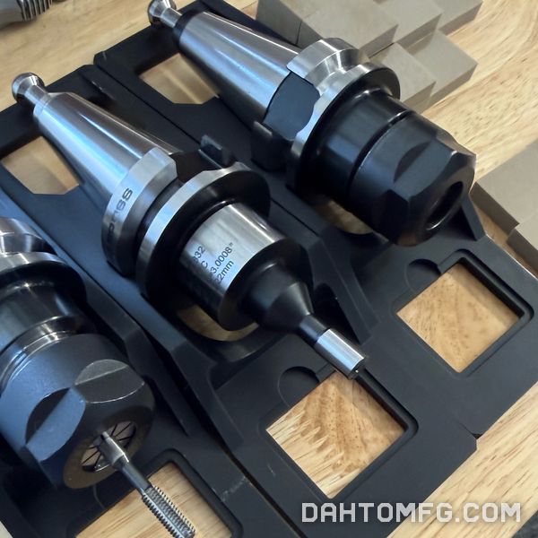Three CNC tool holders in a holder tray, with calipers nearby